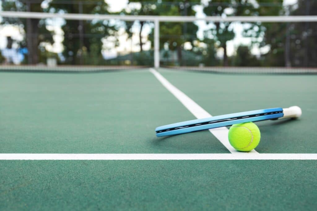 Tennis racket and ball on the court.